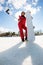 Woman with the snowboard using smartphone on a stick to making selfie