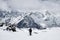 Woman snowboarder climbs the mountain through the snow backcountry with a snowboard behind her shoulders. Climb the