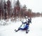 Woman and Snowmobile in Winter Finland, Lapland at Christmas. Extreme Sport Activity and Recreation in Cold Season. Drive a Snow