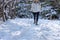 woman snowshoeing along snowy forest trail