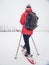 Woman snowshoeing in snow fall. Dark grey clouds