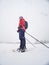 Woman snowshoeing in snow fall. Dark grey clouds