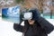 Woman during snowy winter uses virtual reality glasses to see a summer tropical sea