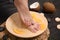 Woman soaking her feet in plate with water and orange slices on wooden floor, closeup.