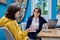 Woman social worker, mentor interviewing, talking to young female in office