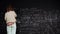 Woman solves scientific problem writing formulas on chalkboard focused on studies