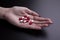 Woman with some drug capsules on palm of hand