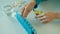 Woman sorts nutritional vitamins in blue tablet box on the week.