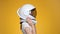 Woman with space helmet on her head on orange background.