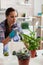 Woman spaying plants in kitchen