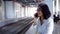 Woman speaking on cellphone in train station