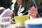 Woman spooning froth on a cappuccino as she sits outdoors