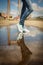 Woman in sport shoes standing in a puddle