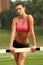 Woman in Sports Bra Leaning on Hurdle with Head Tilted