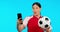 Woman, sports and video call in studio, talk and football celebration, excited and happy by blue background. Girl