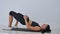 Woman in sportswear doing hip bridge exercise. Joyful attractive young woman lying on floor in living room and doing hip
