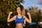 woman in sportswear raising her hands and pulling out muscle as a victory