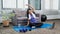 Woman in sportswear is sitting on a mat to do yoga exercise in the indoor living room at home on holiday cozy, relaxing and