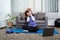 Woman in sportswear is sitting on a mat to do yoga exercise in the indoor living room at home on holiday cozy, relaxing and