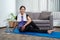 Woman in sportswear is sitting on a mat to do yoga exercise in the indoor living room at home on holiday cozy, relaxing and