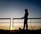 Woman in sportwear standing on the boardwalk with morning sky background , silhouette photo