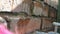 Woman spraying brick wall with water before pointing. Closeup.