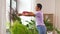 Woman spraying houseplant with water at home