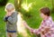 Woman spraying insect or mosquito repellents on little boy before a walk in the forest. Protect children from mosquitoes and other