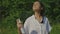 Woman spraying insect repellent on her face outdoor in nature using spray bottle