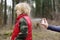 Woman spraying ticks bite repellents on little boy during a walk in the forest. Protect children from dangerous insects while
