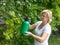 Woman spraying vineyard by pesticide outdoors