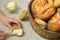 Woman spread the butter on the slice of bread and different bread in the basket