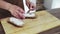 Woman spreading cheese on rye dry toast with a knife.