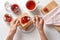 Woman spreading strawberry jam on toast bread