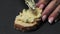 Woman spreads mayonnaise paste with egg, onion and cheese on fresh baguette bread