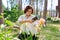 Woman in spring garden enjoying beauty of iris flowers taking pictures of iris with smartphone