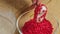 A woman sprinkles heart cake pops with red dressing, close up