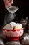 Woman sprinkles homemade cookies with powdered sugar