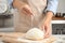 Woman sprinkling dough for pastry with flour