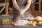 Woman sprinkling flour over table. Pasta recipe