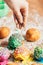 Woman sprinkling sugar strands on doughnuts