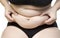 Woman squeeze belly fat wearing black underwear bra and pant on