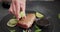 Woman squeezing fresh lime juice onto grilled tuna steak on a black stone serving board with teriyaki soy sauce and