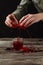 Woman squeezing fresh pomegranate juice into glass on wooden table