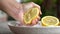 Woman squeezing lemon until its juice and seeds come out.