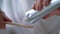 Woman is squeezing toothpaste on bamboo brush.