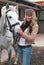 Woman in a stable before riding her horse