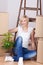 Woman With Stacked Cardboard Boxes Sitting On Floor