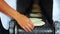 Woman stacking fresh corn tortillas from tortilla making machine traditional mexican