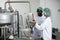 Woman staff worker working train African black man in food factory to operate the machine in clean production room